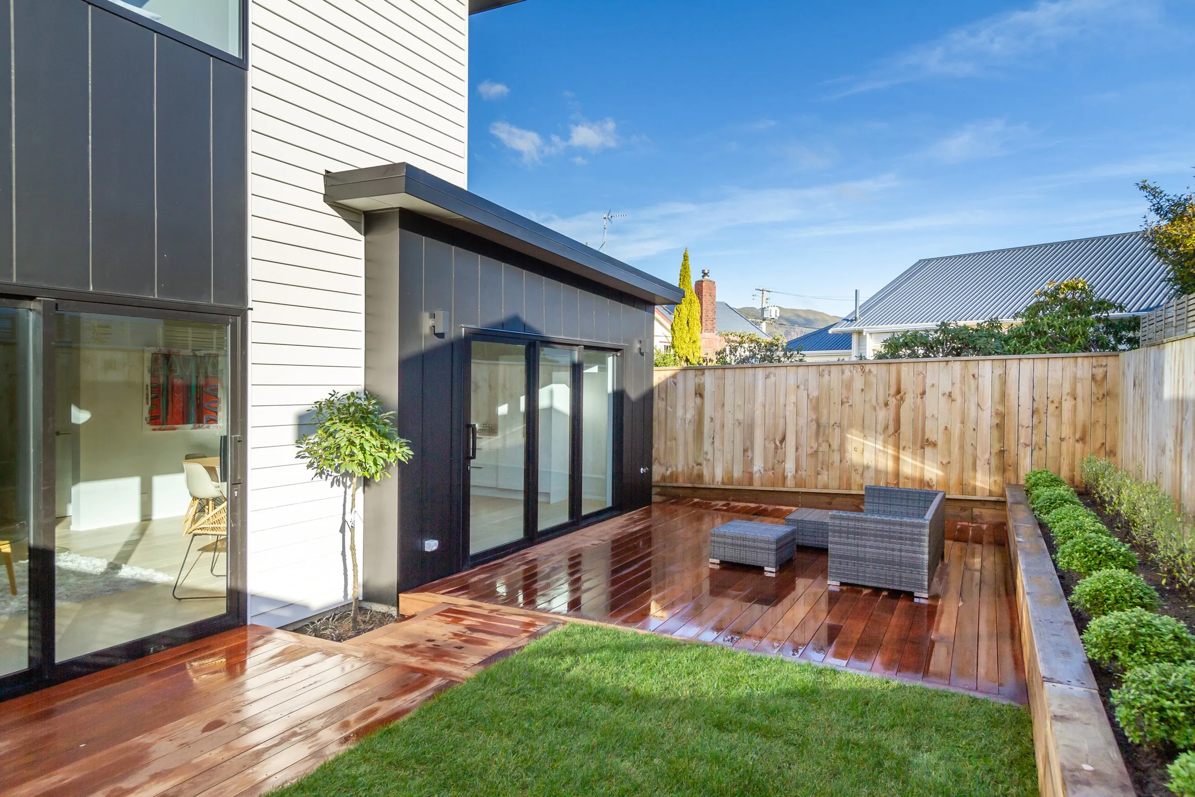 Black clad home with a landscaped garden