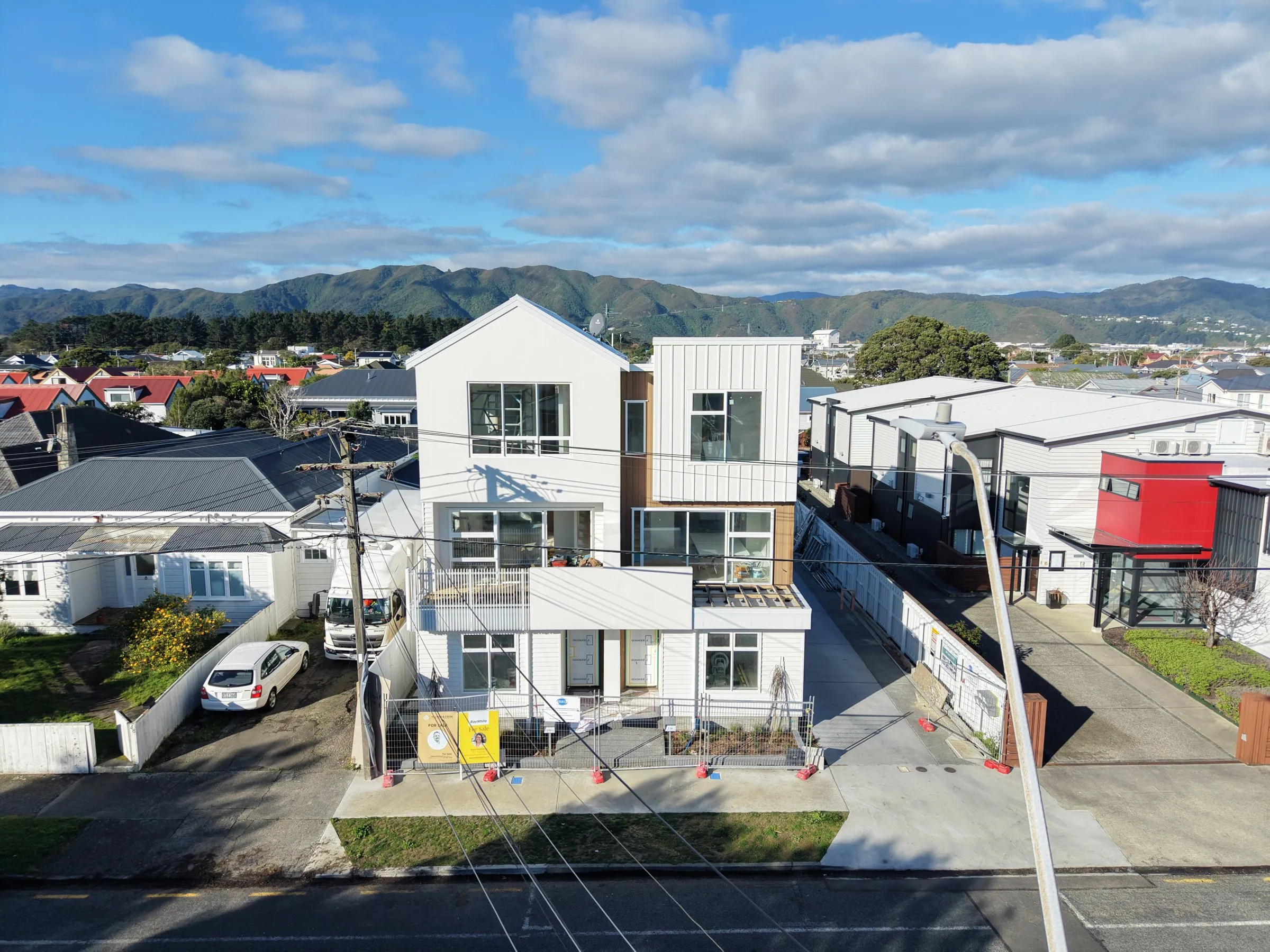 Lola Cuba from the air, new three storey townhouses in Petone with the hills behind